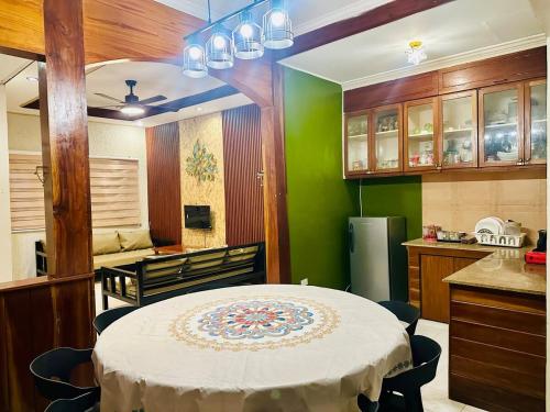 a kitchen with a table and a green wall at The Alusiman Home - 4 bedroom home in Iloilo City