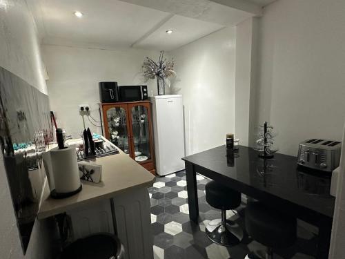 a kitchen with a refrigerator and a table and chairs at Seaside Stay Sleeps 6 with Pets in Great Yarmouth