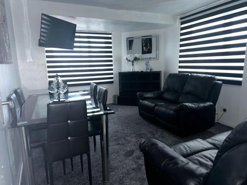a living room with a glass table and leather furniture at Seaside Stay Sleeps 6 with Pets in Great Yarmouth