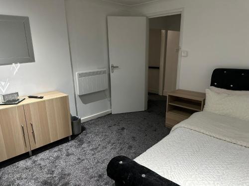 a bedroom with a bed and a dresser with a television at Seaside Stay Sleeps 6 with Pets in Great Yarmouth