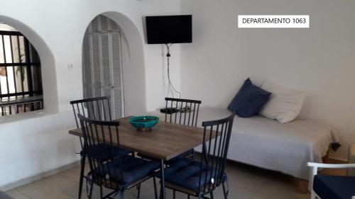 マンサニージョにあるPuerto Las Hadas Apartamentosのテーブルとベッドのあるダイニングルーム