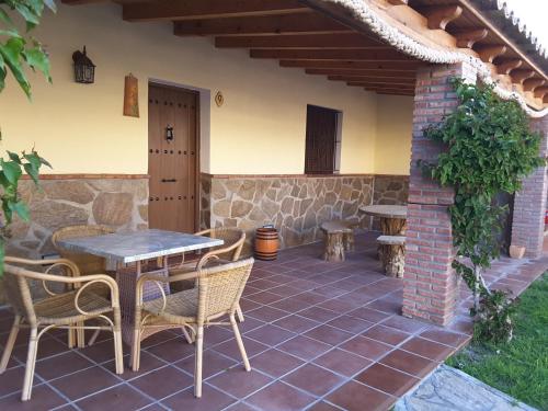 a patio with tables and chairs and a building at Residencial La Teja in Zahora