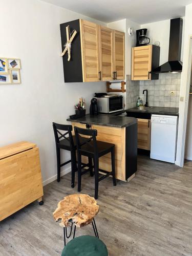 une cuisine avec une table et des chaises et un micro-ondes dans l'établissement Studio à La Foux d 'Allos, à La Foux d'Allos