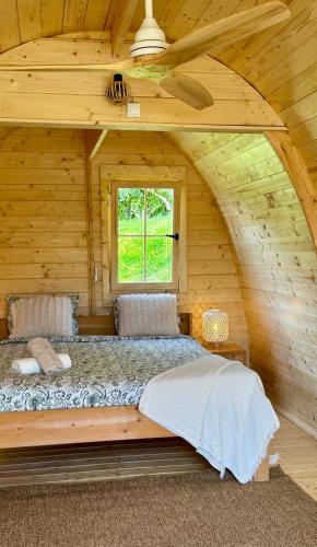 a bed in a log cabin with a window at Quinta da Boa Sorte in Estói