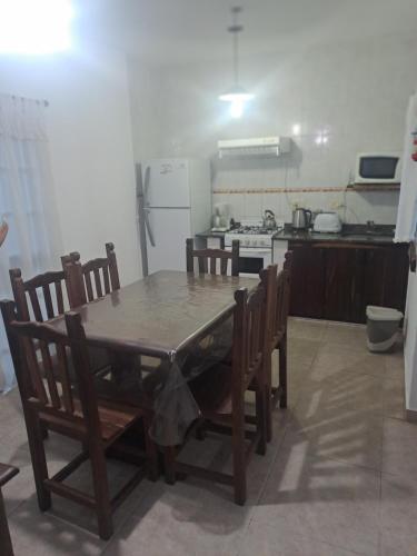 cocina con mesa de madera con sillas y nevera en Las Rosas, en Costa del Este