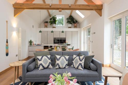 Una sala de estar con un sofá y una cocina. en 2 Bed Converted Barn, en Ombersley