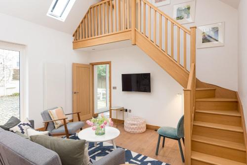 Una sala de estar con un sofá y una escalera. en 2 Bed Converted Barn, en Ombersley