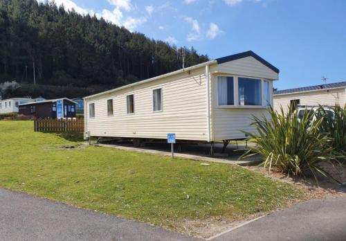 Una casa móvil está estacionada en un patio en Pet Friendly 3 Bed Static Caravan in Clarach Bay Spacious and Cozy Stay, en Aberystwyth
