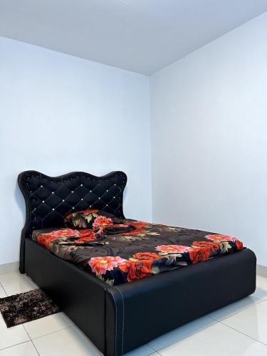 a bed with a black bed frame with a flower blanket at Apartamento Condomínio Vila Flor in Viana