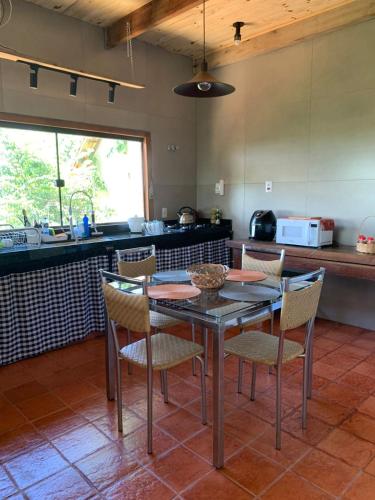 a dining room with a table and chairs in a kitchen at Loft Astanga Serra do Cipó in Serra do Cipo