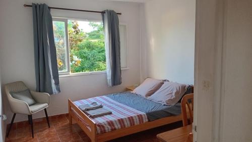 a small bedroom with a bed and a window at Appartement F4 Kone centre Tel 7O 55 O8 in Koné