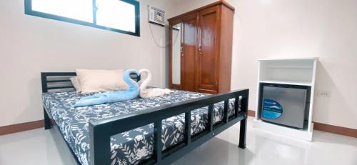 a bedroom with a bed with a toy dolphin on it at Pacific Guesthouse in Ubay
