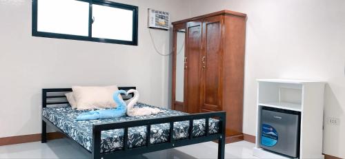 a room with a bed with a stuffed animal on it at Pacific Guesthouse in Ubay