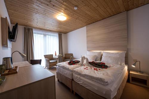 a hotel room with a large bed and a desk at Horský hotel Lorkova vila in Čeladná