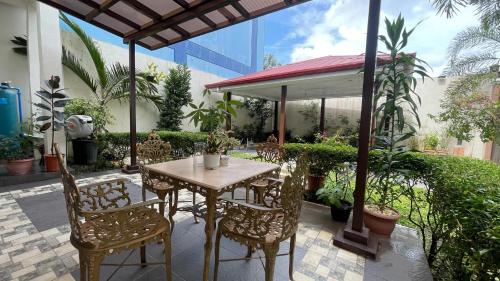 a table and chairs on a patio with plants at Abucay Guests House in Utap