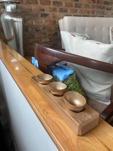 three metal bowls on a wooden counter top at VILLA DE MOYA HOTEL MONGUI in Monguí