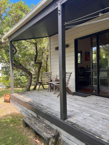 a porch of a house with a table and chairs at Whangapoua Paradise in Whangapoua