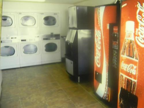 a laundry room with a refrigerator and washing machines at America's Best Value Inn Conyers in Conyers