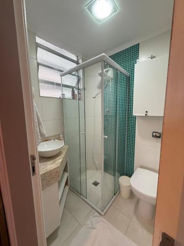 a bathroom with a shower and a toilet and a sink at Studio luxo em Santos vista ao mar in Santos