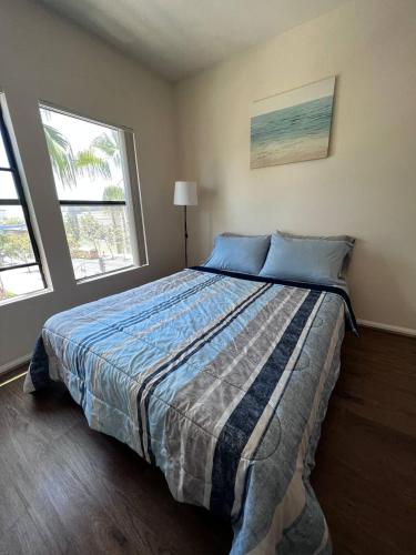 a large bed in a bedroom with two windows at ELEGANT RESORT-SoCal-Lux on 3rd in Los Angeles