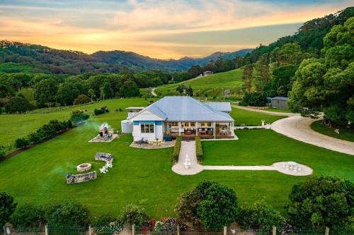 an aerial view of a house on a green field at Luxury Farm Homestead & Animal Sanctuary, Hot Tub in The Pocket