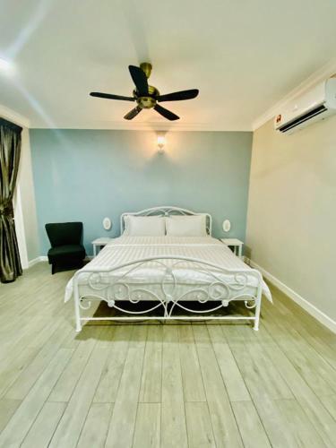 a bedroom with a white bed with a ceiling fan at Soulmate Village in Hulu Langat