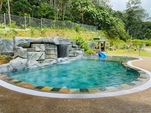 a swimming pool with a waterfall in a park at Soulmate Village in Hulu Langat