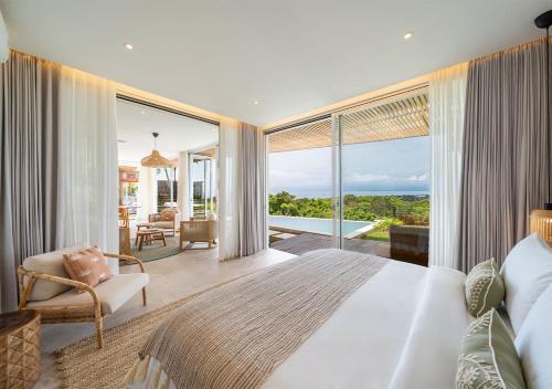 een slaapkamer met een groot bed en uitzicht op de oceaan bij Villa Utopia in Nusa Lembongan