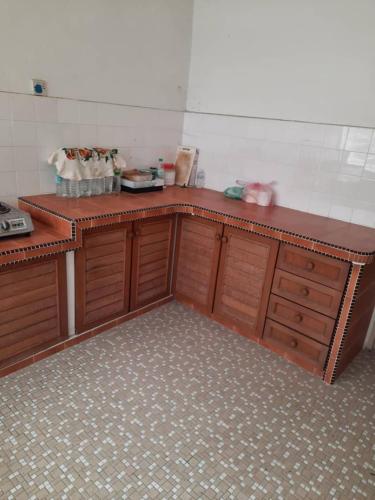 a kitchen with wooden cabinets and a counter top at Rumah Teres Teluk Kumbar in Bayan Lepas