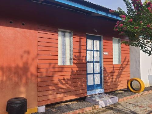 a red house with a blue door and windows at Tmn Rekreasi Cikgu Haron in Labis