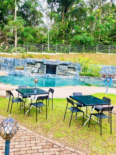 a picnic table and chairs in front of a swimming pool at Soulmate Village in Hulu Langat