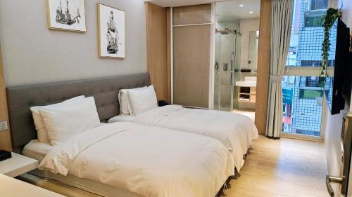 a hotel room with two beds and a window at Hotel Mapp in Taichung