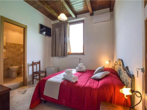 a bedroom with a red bed with towels on it at Apartment with Jacuzzi near Etna in Gaggi