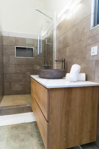 a bathroom with a wooden sink and a shower at Salty Breeze in Flic-en-Flac