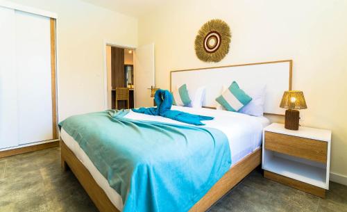 a bedroom with a large bed with blue sheets at Salty Breeze in Flic-en-Flac