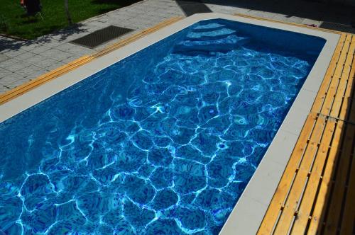 a swimming pool with blue water in the middle at Tunduk Hostel in Bishkek