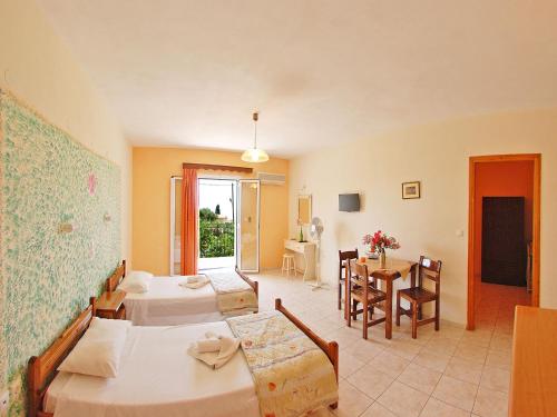 a hotel room with two beds and a table at Emilia Apartments in Trapezaki