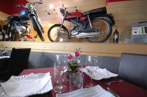 a table with wine glasses and a motorcycle on a wall at Hotel Cuéntame in Burgos