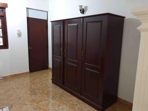 a large wooden cabinet in a room with a wall at Heritage Bungalow Hikkaduwa in Hikkaduwa