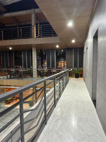 a balcony of a building with tables and chairs at New Life Homestay in Phan Thiet