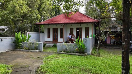 a small white house with a red roof at Jepun Homestay Lemukih in Singaraja