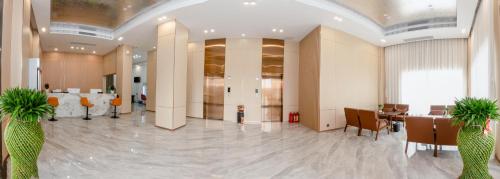 a lobby with two palm trees in a building at 新骏龙酒店 in Phumĭ Bavĕt (2)