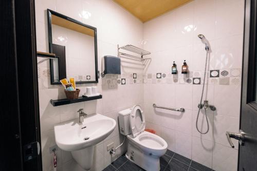 a bathroom with a toilet and a sink and a shower at 玉井拱月民宿 in Yujing