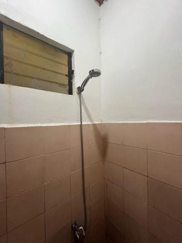 a shower in a tiled bathroom with a window at Zia"s homestay-3 in Cangalwang