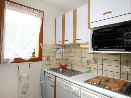 une cuisine avec un évier et un micro-ondes dans l'établissement Appartement 2 pièces avec parking privé à La Salle-les-Alpes - FR-1-762-41, à La Salle Les Alpes