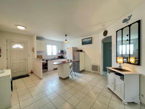 une grande cuisine avec une table et un comptoir dans l'établissement Maison familiale 3 chambres avec jardin à 400m de la plage, accès WIFI - FR-1-231-333, à Bretignolles-sur-Mer