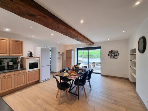 a kitchen and dining room with a table and chairs at Deux Gîtes Accueillants avec Wifi et Animaux Admis - FR-1-496-344 in Pouilly-les-Feurs