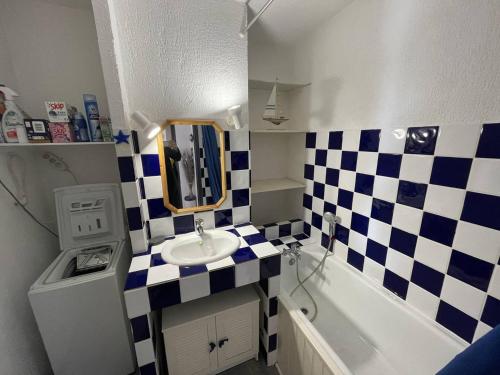 - une petite salle de bains avec un sol en damier et un lavabo dans l'établissement Appartement centre port, terrasse, piscine, proche mer - FR-1-723-171, au Cap d'Agde