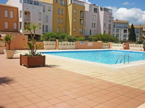 une grande piscine dans une ville avec des immeubles dans l'établissement Appartement centre port, terrasse, piscine, proche mer - FR-1-723-171, au Cap d'Agde