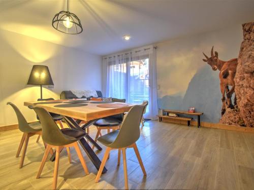 une salle à manger avec une table et des chaises ainsi qu'une fresque murale représentant des cerfs dans l'établissement Appartement moderne au centre de Morzine avec parking - FR-1-524-136, à Morzine